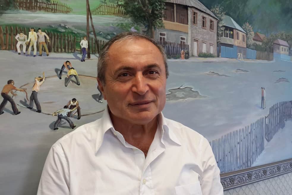 שלום שי // בעלים ומנכל חברת דונה על רקע ציור בית ילדותו בגיאורגיה