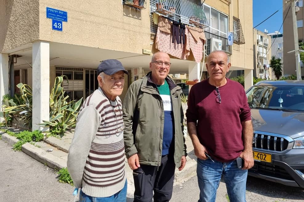 מימין- עזרא קבע , שמואל הנדלר ואלי ועקנין על רקע הבניינים במתחם רובינשטיין // צילום: החברה לפיתוח התחדשות עירונית